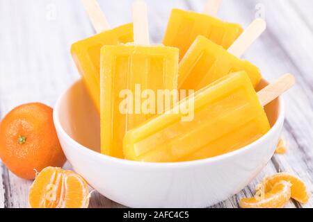 Porzione di freschi fatti in casa Popsicles mandarino (close-up shot; messa a fuoco selettiva) su un sfondo vintage Foto Stock