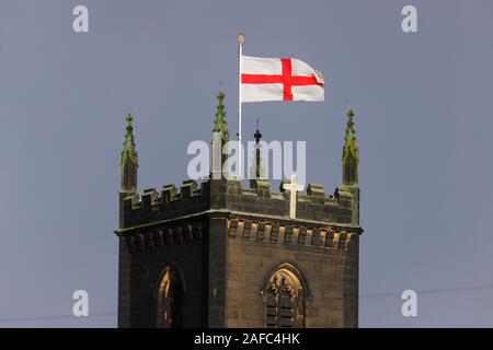 A St George bandiera, battenti orgogliosa sopra chiesa di Santa Maria in Swillington,West Yorkshire, Regno Unito Foto Stock