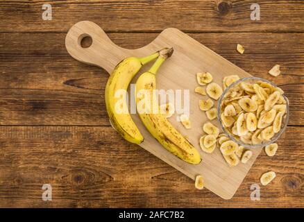 In casa Banane essiccate chip su un tavolo di legno come dettagliato di close-up shot; messa a fuoco selettiva Foto Stock