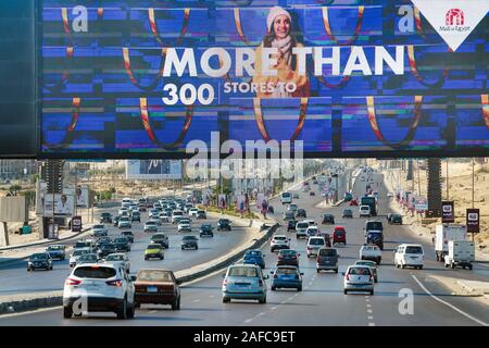 Le gigantesche insegne pubblicitarie bilboard oltre l'autostrada per il 6th.Ottobre quartiere a soli al di fuori de Il Cairo, Egitto Foto Stock