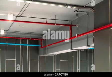 Sistema antincendio automatico sistema di sicurezza rosso e tubazione di alimentazione di acqua. Fire Suppression. Protezione antincendio e rivelatore. Sistema antincendio con tubo rosso Foto Stock