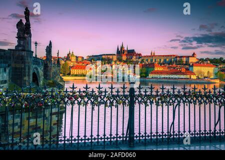 Ferro battuto recinzione ringhiera e decorate con romantiche lucchetti colorati. Ben noti edifici e sedi di sunrise a Praga Repubblica Ceca, Eur Foto Stock