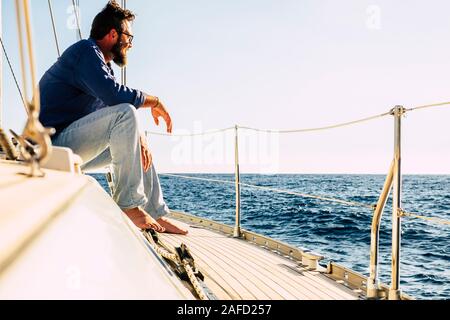 Concetto di persone in viaggio con uomo caucasico sedersi su una imbarcazione a vela guardando l'oceano blu e godendo l'escursione o un lusso lifetyle - outdoor Foto Stock