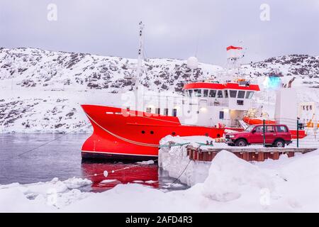 Rosso pesca barca ancorata nella neve laguna. porto di Nuuk, Groenlandia Foto Stock