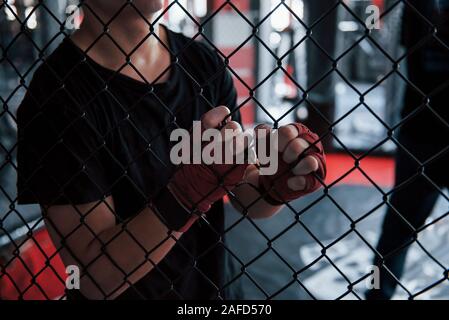 Prendendo una pausa. Sportivo al pugilato ring hanno esercizio. Poggiando su la recinzione Foto Stock