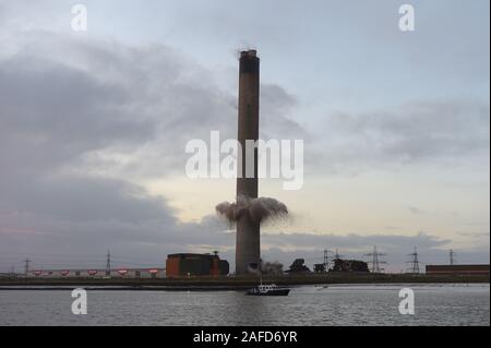 Dartford, Kent, Regno Unito. Il 15 dicembre 2019. La demolizione dei 215 metri di camino al Littlebrook Power Station è il prossimo passo per lo smantellamento degli impianti chiusi nel 2015 e ha aperto per la prima volta come una centrale a carbone stazione in 1939 ed è stato un sistema di navigazione per la Luftwaffe durante il WW2. Il blast condotta da Kent base impresa di demolizione marrone e Mason ha causato una temporanea chiusura del vicino QE2 ponte che attraversa il fiume Tamigi da Essex di Kent. Il camino si fermò due volte alto come il Big Ben e è stato il secondo più grande nel regno Unito. Credito: Martin Dalton/Alamy Live News Foto Stock