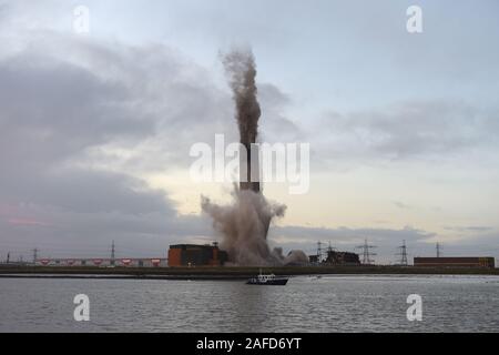 Dartford, Kent, Regno Unito. Il 15 dicembre 2019. La demolizione dei 215 metri di camino al Littlebrook Power Station è il prossimo passo per lo smantellamento degli impianti chiusi nel 2015 e ha aperto per la prima volta come una centrale a carbone stazione in 1939 ed è stato un sistema di navigazione per la Luftwaffe durante il WW2. Il blast condotta da Kent base impresa di demolizione marrone e Mason ha causato una temporanea chiusura del vicino QE2 ponte che attraversa il fiume Tamigi da Essex di Kent. Il camino si fermò due volte alto come il Big Ben e è stato il secondo più grande nel regno Unito. Credito: Martin Dalton/Alamy Live News Foto Stock