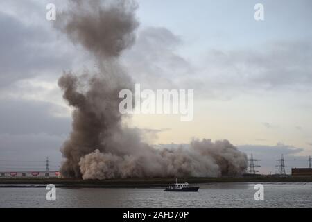 Dartford, Kent, Regno Unito. Il 15 dicembre 2019. La demolizione dei 215 metri di camino al Littlebrook Power Station è il prossimo passo per lo smantellamento degli impianti chiusi nel 2015 e ha aperto per la prima volta come una centrale a carbone stazione in 1939 ed è stato un sistema di navigazione per la Luftwaffe durante il WW2. Il blast condotta da Kent base impresa di demolizione marrone e Mason ha causato una temporanea chiusura del vicino QE2 ponte che attraversa il fiume Tamigi da Essex di Kent. Il camino si fermò due volte alto come il Big Ben e è stato il secondo più grande nel regno Unito. Credito: Martin Dalton/Alamy Live News Foto Stock