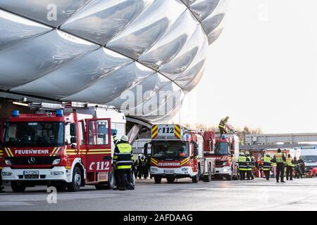 Monaco di Baviera, Germania. 15 Dic, 2019. Veicoli di emergenza dei vigili del fuoco sono in piedi nella parte anteriore della Allianz Arena durante un disastro esercizio di controllo per il Campionato Europeo di Calcio 2020. Durante l'esercizio, l'esplosione di una friggitrice in uno snack bar all'interno dell'arena è stato simulato con un attacco in massa di persone ferite. Il giunto di comando di emergenza esercizio "EMÜ19' di vigili del fuoco, polizia, servizi di salvataggio, la città di Monaco di Baviera e il tedesco Football Association serve a preparare per la UEFA Campionato Europeo 2020. Credito: Matthias esitano di fronte/dpa/Alamy Live News Foto Stock