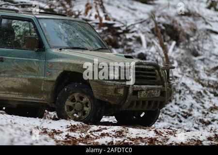 Off-road corse in auto in discesa su neve e fango in foresta Foto Stock