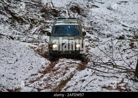 Off-road corse in auto in discesa su neve e fango in foresta Foto Stock