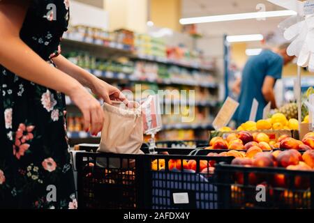 La donna si sceglie di frutta e verdura del mercato alimentare. Borsa riutilizzabile shopping. Rifiuti Zero Foto Stock