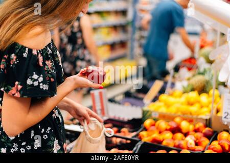 La donna si sceglie di frutta e verdura del mercato alimentare. Borsa riutilizzabile shopping. Rifiuti Zero Foto Stock