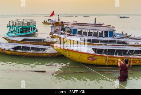 Barche in legno all alba del fiume Gange a Varanasi, India Foto Stock