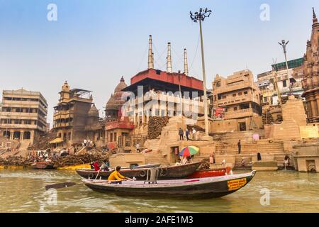 Le barche che vanno dalla cremazione ghat di Varanasi, India Foto Stock