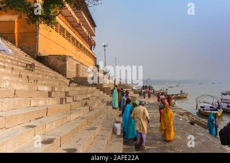 Persone presso le scale che portano al fiume Gange a Varanasi, India Foto Stock