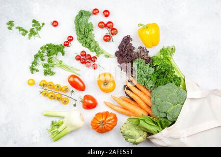 Rifiuti Zero heatlhy concetto dello shopping. Verdure battenti fuori del cotone riutilizzabile borsa su off cucina bianca top, vista aerea, il fuoco selettivo Foto Stock