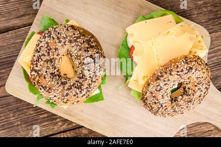 La colazione (bagel con formaggio; il fuoco selettivo) su un vecchio tavolo in legno Foto Stock