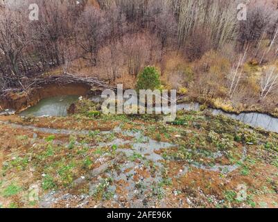 La grande heap dump di rifiuti si estende parallelamente al fiume,Garbage montagne con cielo nuvoloso di massa indietro in giorno luce,rifiuti ha prodotti petroliferi sono Foto Stock