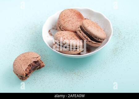 Il cioccolato macarons dolci contro lo sfondo del ciano Foto Stock