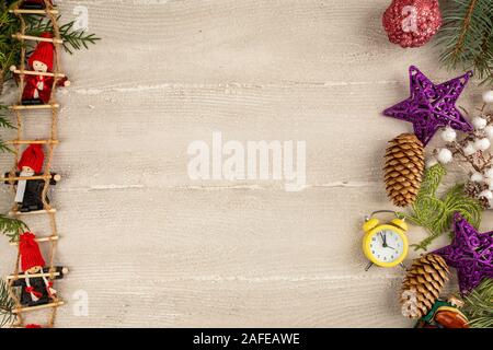 Little dwarf bambole sono seduti sulle scale di Natale. Luce di sfondo in legno e decorazioni di Natale. Spazio di copia Foto Stock