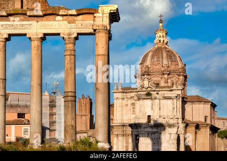 Resti di colonne del tempio di Saturno e la cupola della chiesa dei Santi Luca e Martina, Roma, Italia Foto Stock