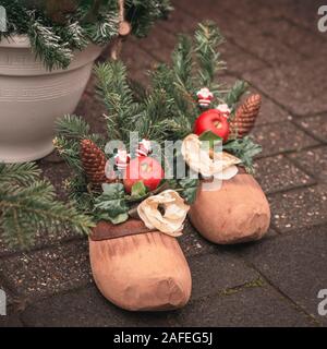 Christmas Festive composizione con vintage scarpa in legno per St Nicholas giorno, rami di abete rosso, coni, festosa home decor Foto Stock