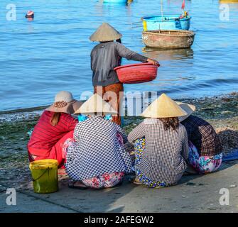 Phan Thiet, Vietnam - Mar 19, 2016. Le donne con i tradizionali cappelli lavora al villaggio di pescatori di Phan Thiet, Vietnam. Foto Stock