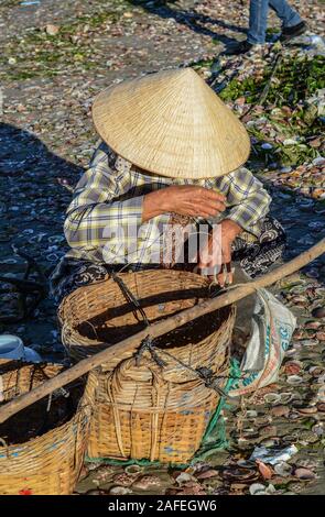 Phan Thiet, Vietnam - Mar 19, 2016. Le donne con i tradizionali cappelli lavora al villaggio di pescatori di Phan Thiet, Vietnam. Foto Stock