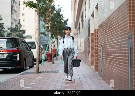 (191215) -- MACAO, Dic 15, 2019 (Xinhua) -- Yu nel peccato è sulla sua strada per la scuola di Macao, Cina del sud, nov. 25, 2019. Il 10-anno-vecchio Yu, nato a Macao, è un quinto grado di studente della Scuola di Premier affiliate a Hou Kong scuola media. Suo fratello anche gli studi presso la scuola. Agli occhi di sua madre, Yu nel peccato è un ottimista, soleggiata e vivace ragazza con molti talenti. Ha vinto molti premi in Macao studenti della scuola primaria' storytelling, recita, arte e competizioni di ballo. Sebbene nato dopo Macao il suo ritorno alla Cina, Yu imparato molto circa la patria nei suoi libri di testo. 'My Foto Stock