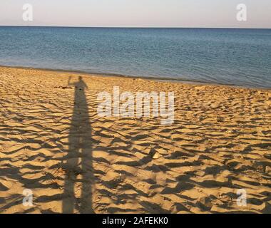 Uomo ombra sulla spiaggia mediterranea, Grecia Foto Stock