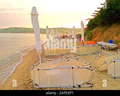 Ombrelloni e lettini in spiaggia nelle prime ore del mattino Foto Stock