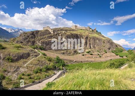 Una vista panoramica sulla storica e le rovine del castello di Tourbillon nella città di Sion (Sitten) in Svizzera (Cantone Vallese/Valais) sotto un meraviglioso blu Foto Stock