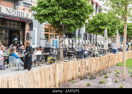 Ixelles, Bruxelles / Belgio - 05 31 2019: Persone che mangiano, parlano e bevono nelle terrazze soleggiate della piazza Fernand Cocq Foto Stock