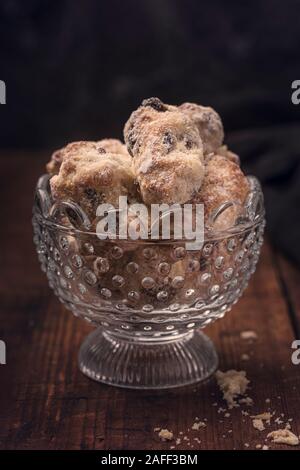 Tradizionale tedesco stollen mini torte in una ciotola di vetro su un vecchio rustico tavolo. Con uno sfondo scuro. Foto Stock