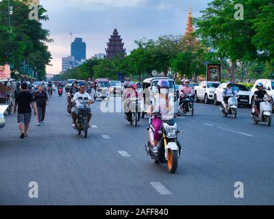 Traffico di sera su Preah Sihanouk Blvd vicino al Norodom Sihanouk Memorial, che appare sullo sfondo. Foto Stock