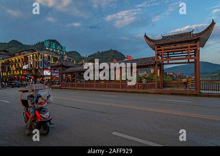 Wulingyuan, Cina - Agosto 2019 : uomo cinese in sella a una moto su una strada nella parte antica della città Wullingyuan Foto Stock