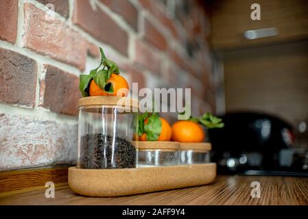 vasi di vetro in cucina con mandarini freschi Foto Stock