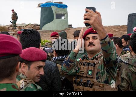 Un soldato Peshmerga fissa la sua beret prima riunione regionale comandante Peshmerga magg. Gen. Sirwan Barzani, e DEGLI STATI UNITI Esercito Col. Scott Holden, Kurdistan Centro di Coordinamento direttore, nella regione del Kurdistan in Iraq 14 Dicembre 2019 Gwer, Iraq. Foto Stock