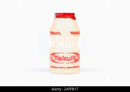 Una bottiglietta di Yakult addolcito probiotici bevanda di latte shot su uno sfondo bianco. Foto Stock