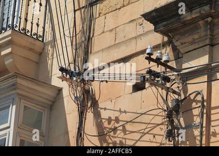 Fastidiosi cavi elettrici su edifici in Malta Foto Stock