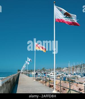 Una diminuzione in prospettiva della scogliera lungomare accanto a una sfilata di bandiere a Santa Barbara Porto di Santa Barbara, CA, Stati Uniti d'America Foto Stock