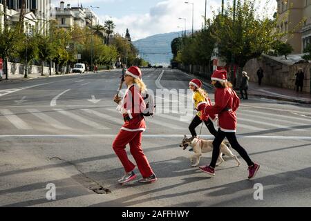 Atene, Grecia. 15 gennaio, 2020. La gente vestita come Santa Claus eseguire con il loro cane durante la gara.Santa Run è una gara sociale evento che si svolge ogni anno in molte città durante il periodo di Natale e con il suo profitto supporta vari enti di beneficenza. Credito: Nikos Pekiaridis SOPA/images/ZUMA filo/Alamy Live News Foto Stock