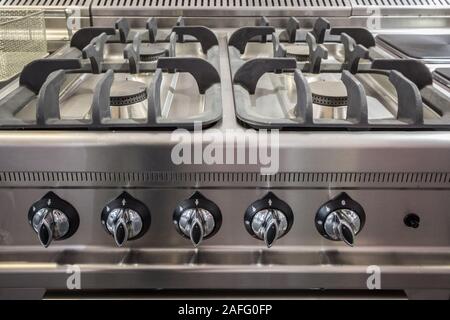 Fornello a gas, un professionista uno in acciaio alluminio, sul display, nuovo di zecca, con bruciatori inutilizzati. Questi tipi di cucine a gas vengono utilizzati in ambienti professionali Foto Stock