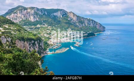 A high angle, panoramic view of the north side of the beautiful resort island of Capri, with its steep limestone cliffs and azure water. Foto Stock