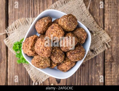 Porzione di fresche fatte le polpette di carne (dettagliate di close-up shot) su sfondo di legno Foto Stock