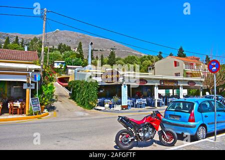Una tipica piccola Taverna Greca sul lato della strada principale attraverso il grazioso villaggio di pescatori di Agia Effimia, e si affaccia sul porto e marina. Foto Stock