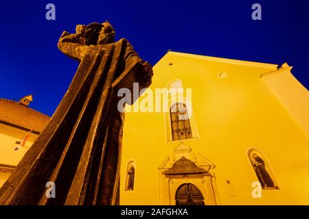 Un monumento di Grgur Ninski davanti la chiesa francescana di San Giovanni Battista in città Varazdin, Croazia Foto Stock