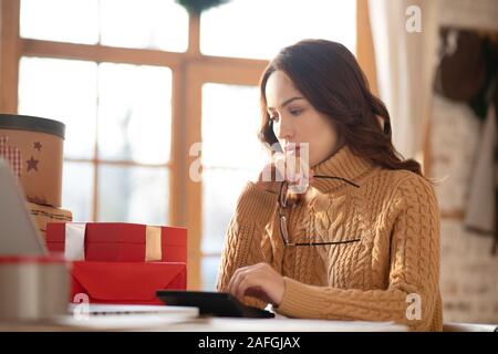 Carino donna in maglia maglione seduti a tavola Foto Stock
