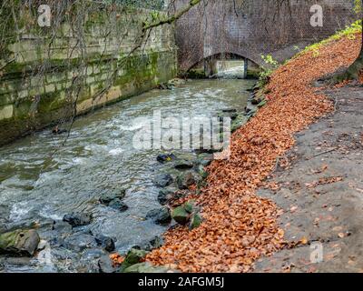 Il livello degli occhi vista lungo il fiume verso un piccolo ponte nella città di Maastricht, Paesi Bassi Foto Stock